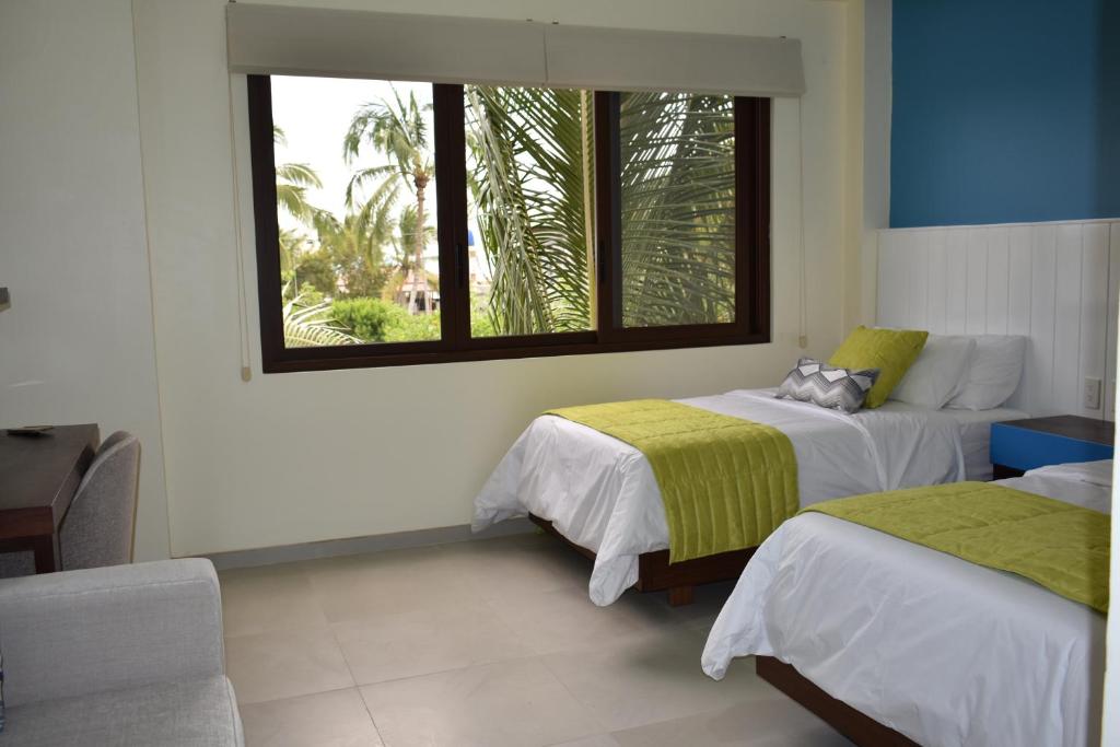 比亚米尔港Hotel La Laguna Galapagos的一间卧室设有两张床和窗户。