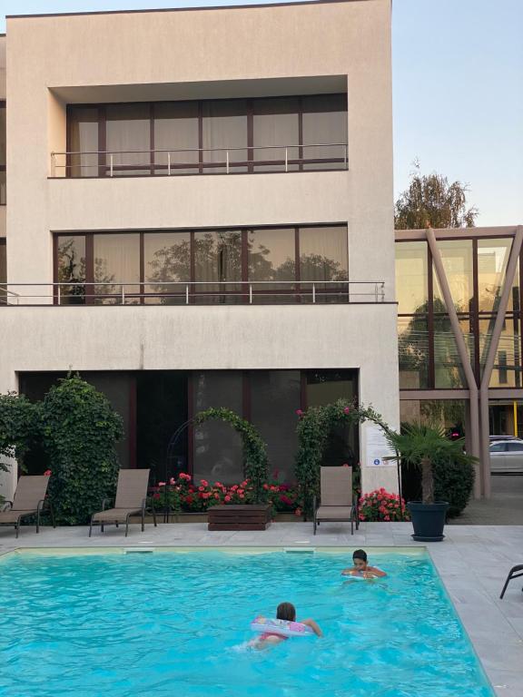 蒂米什瓦拉皮尔拉酒店的两人在大楼前的游泳池游泳