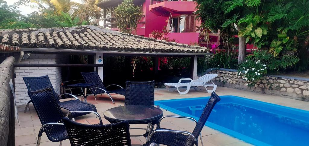 阿拉亚尔达茹达Novos Baianos Hostel e Pousada的一个带桌椅的庭院和一个游泳池