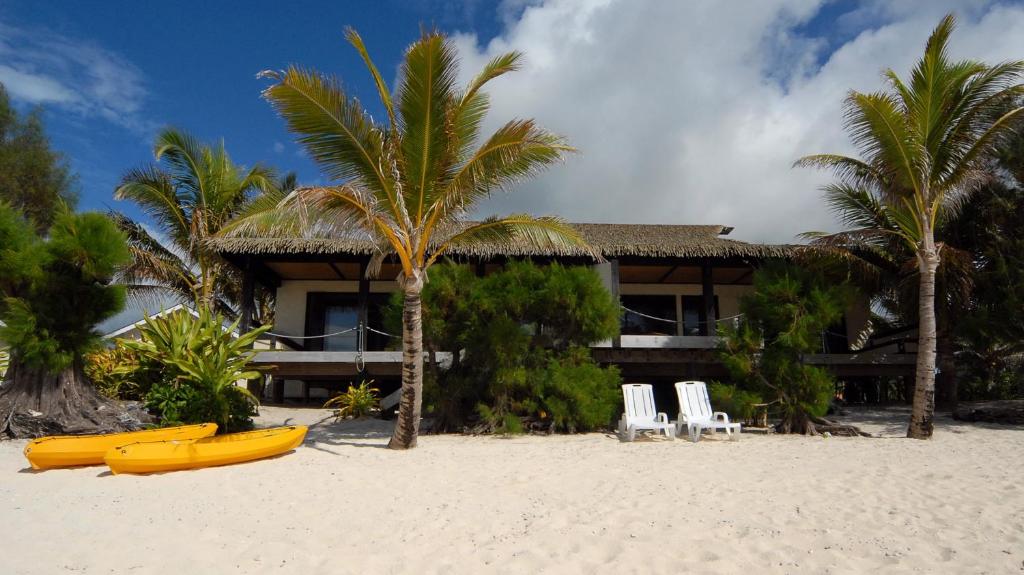 拉罗汤加朗德屋别墅酒店的海滩上的度假村,海滩上设有2艘黄色皮艇