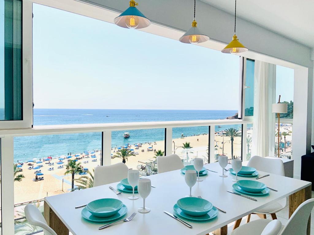 罗列特海岸Seafront New Apartment Boutique的一间设有桌子并享有海滩美景的用餐室