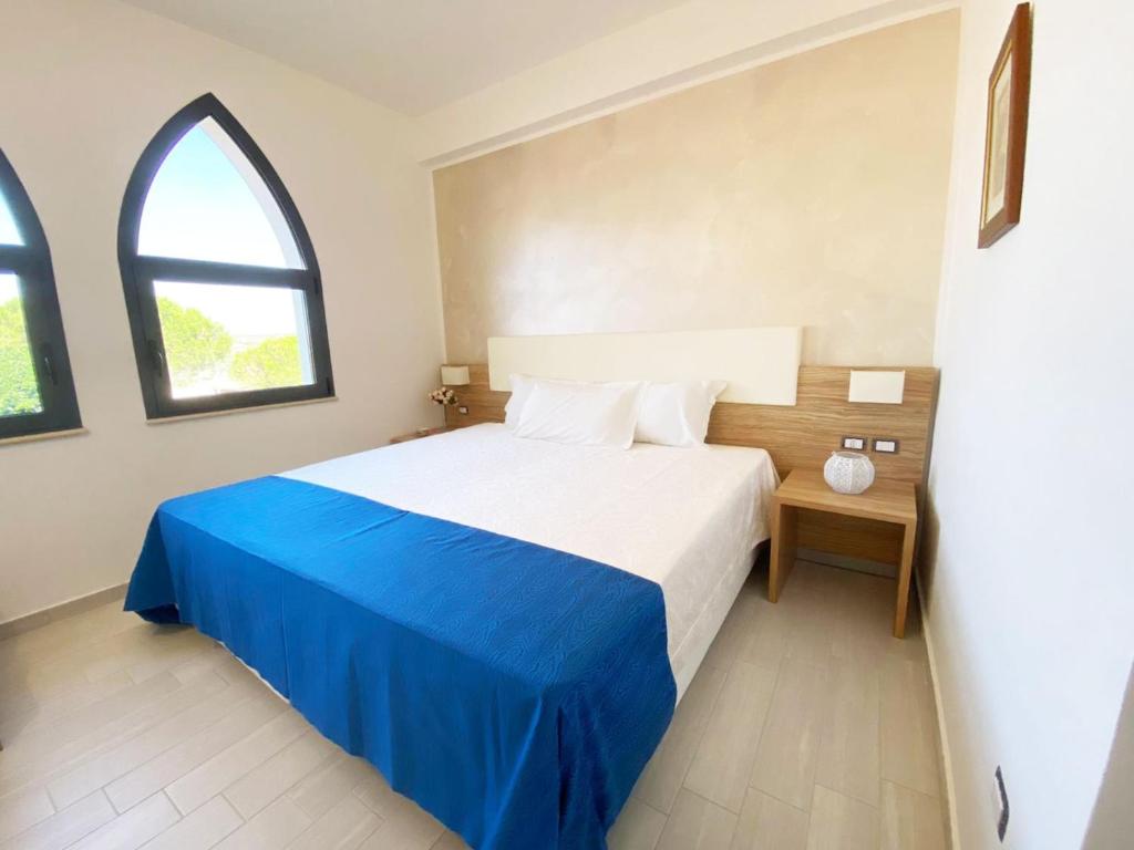 伊索拉迪卡波里祖托La Rustica Hotel的卧室配有蓝色和白色的床和窗户。