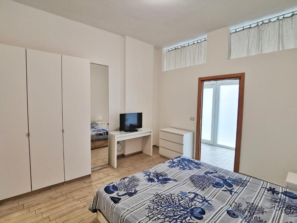 塔兰托All' Ombra del Faro - Mini Apartments的一间卧室配有一张床和一台电视。