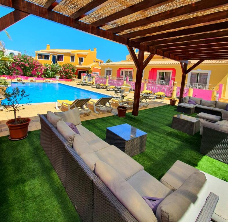 拉戈斯Vila Graciosa - Tranquility Oasis的带沙发的户外庭院和游泳池