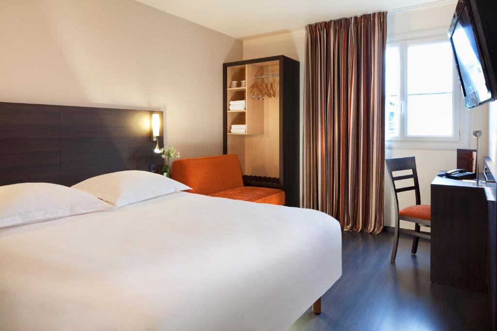 布格奈斯Escale Oceania Nantes Aéroport的酒店客房设有一张白色大床和一张书桌