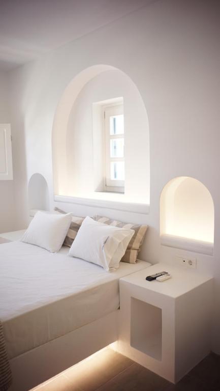 乔拉弗雷恩多斯Paraporti的白色卧室配有床和桌子