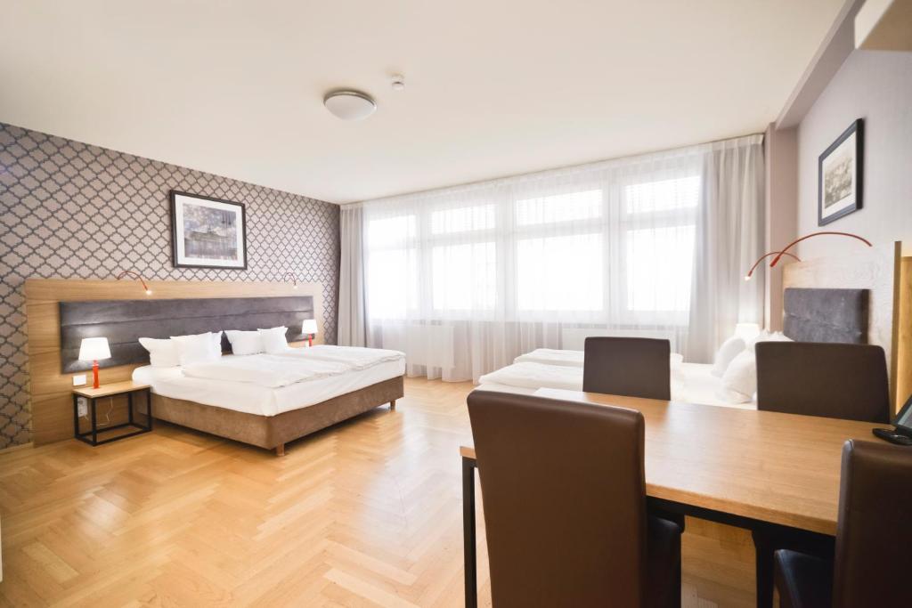 柏林AMC Apartments Ku'damm & Bundesallee的一间卧室配有一张床铺和一张桌子,还有一间用餐室