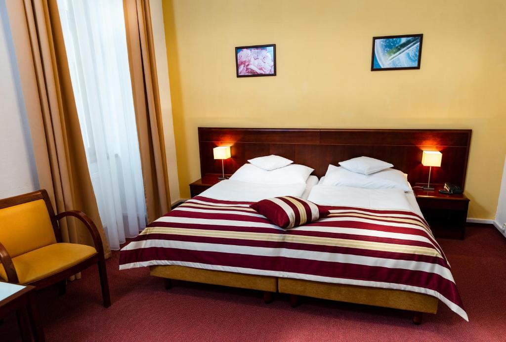 布拉格佩特酒店的酒店客房,配有带条纹毯子的床