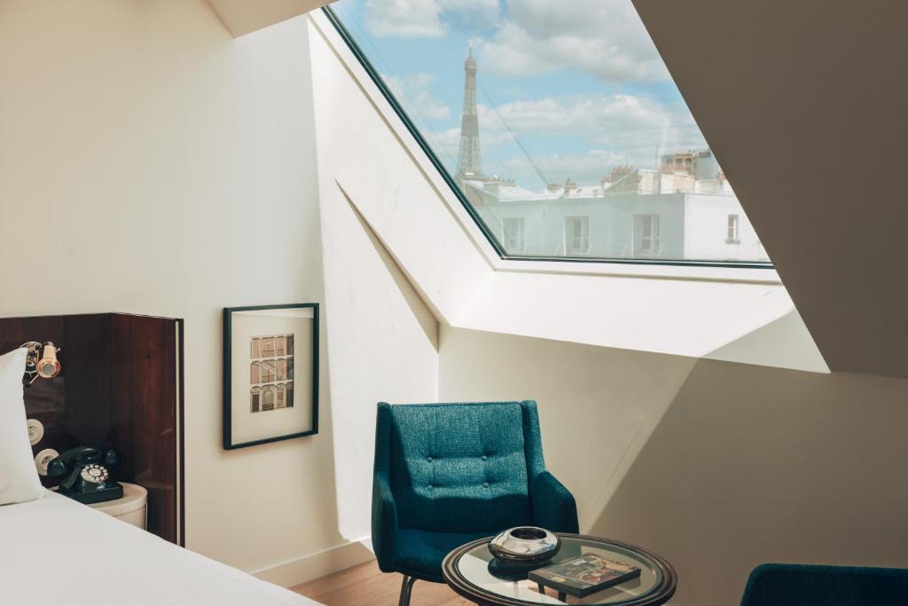 巴黎Hôtel Wallace - Orso Hotels的一间卧室配有蓝色椅子和窗户