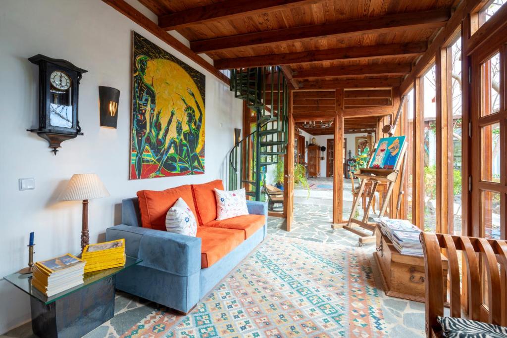 蒂纳霍Villa El Inti的客厅配有橙色沙发和时钟