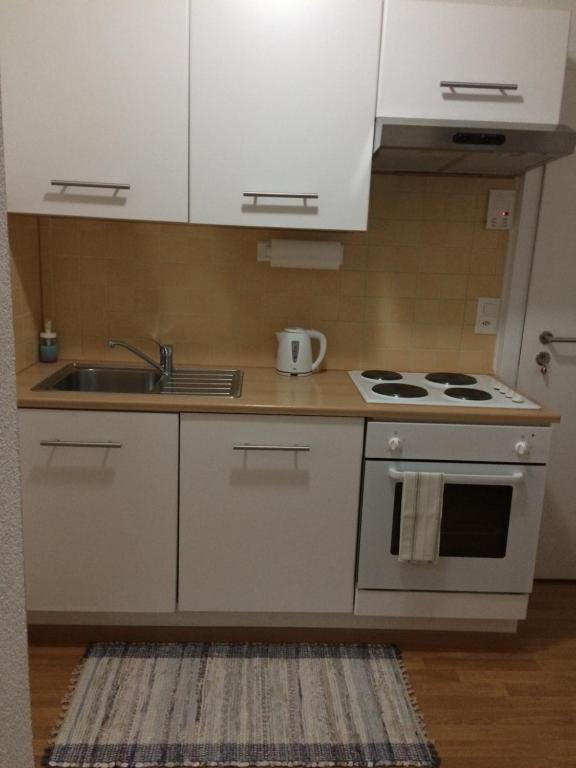 温特图尔1,5 Zimmer Appartement的厨房配有白色橱柜、水槽和炉灶。