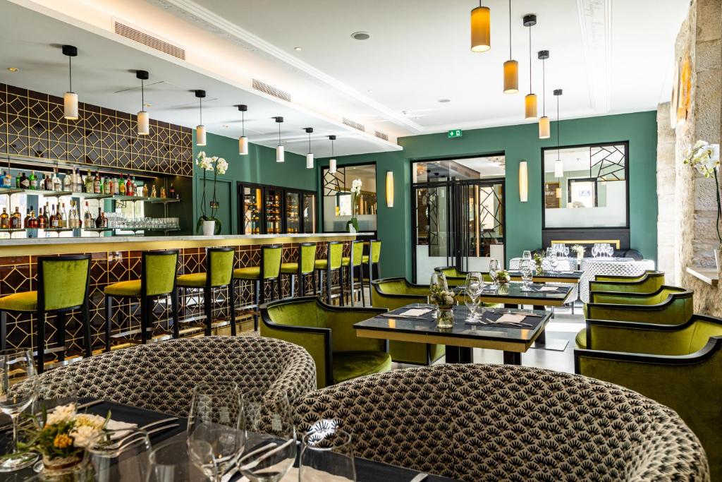 皮利尼蒙特拉谢Olivier Leflaive Hôtel Restaurants的餐厅拥有绿色的墙壁和桌椅