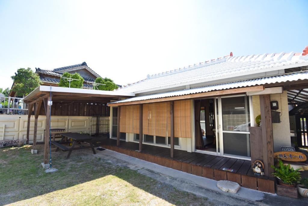 名户Nago - House - Vacation STAY 88505的房屋设有门廊和户外野餐桌