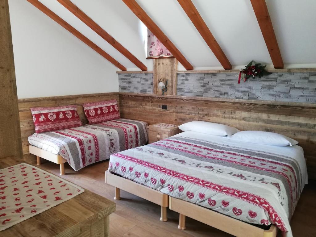 费拉迪普利米罗Agritur le Vale的阁楼上的卧室配有两张床