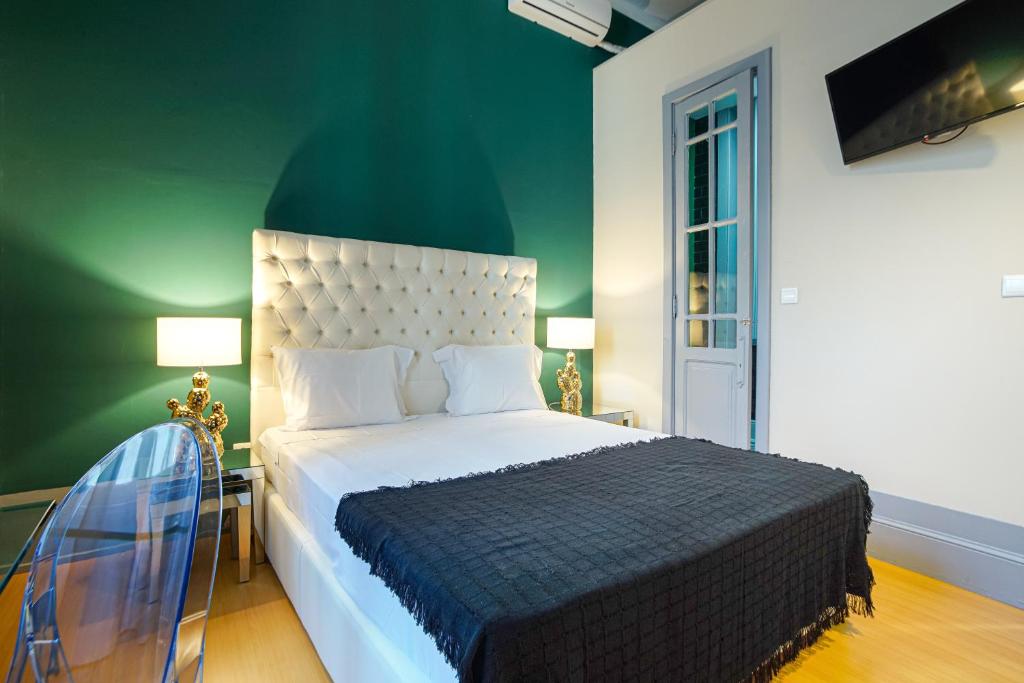 阿威罗Patio79 Aveiro的一间卧室设有一张大床和绿色的墙壁