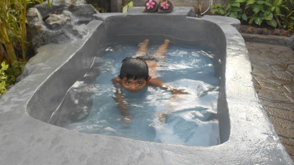 班尤温当Taman Menjangan homestay by SnorkelingMenjangan的在一个热水浴缸中游泳的男孩