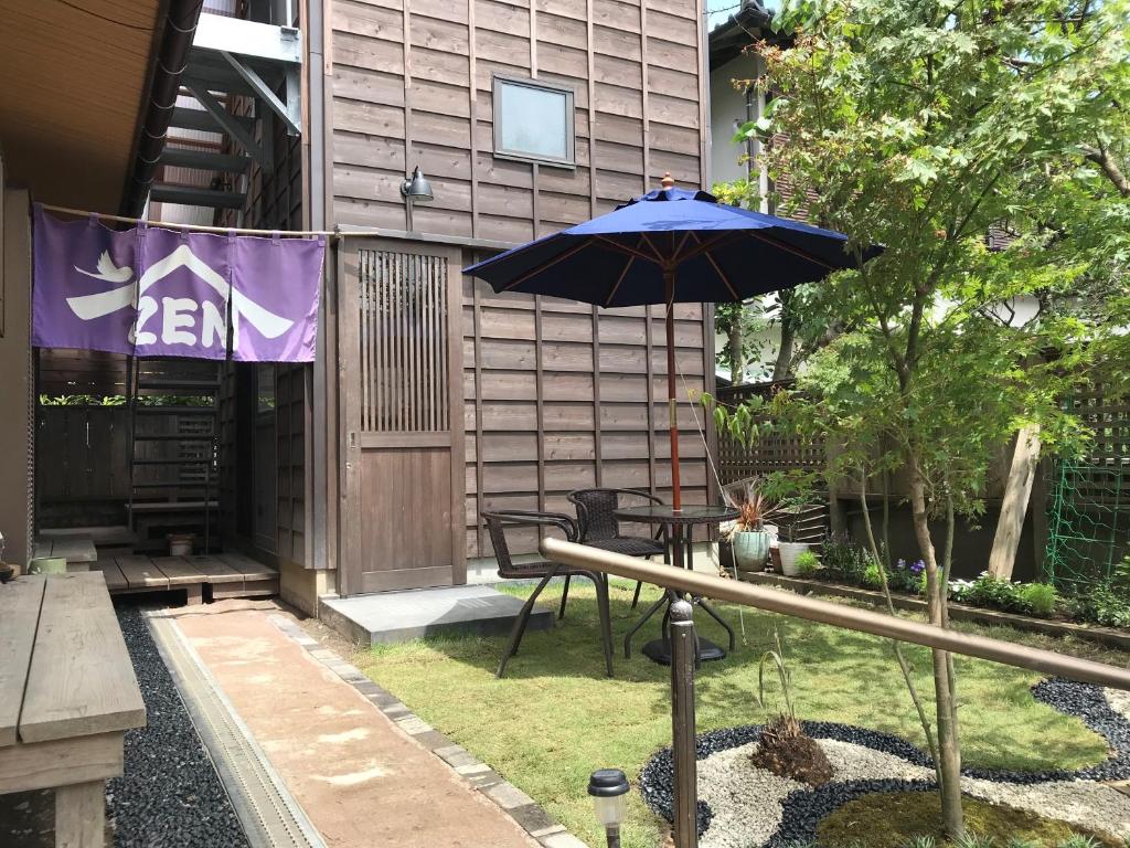 镰仓市镰仓泽杰旅馆的一个带桌子和遮阳伞的庭院