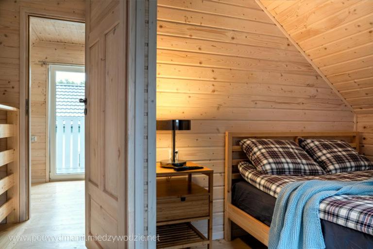 米泽德沃兹Domki Pod Wydmami的小木屋卧室配有1张床和1张书桌
