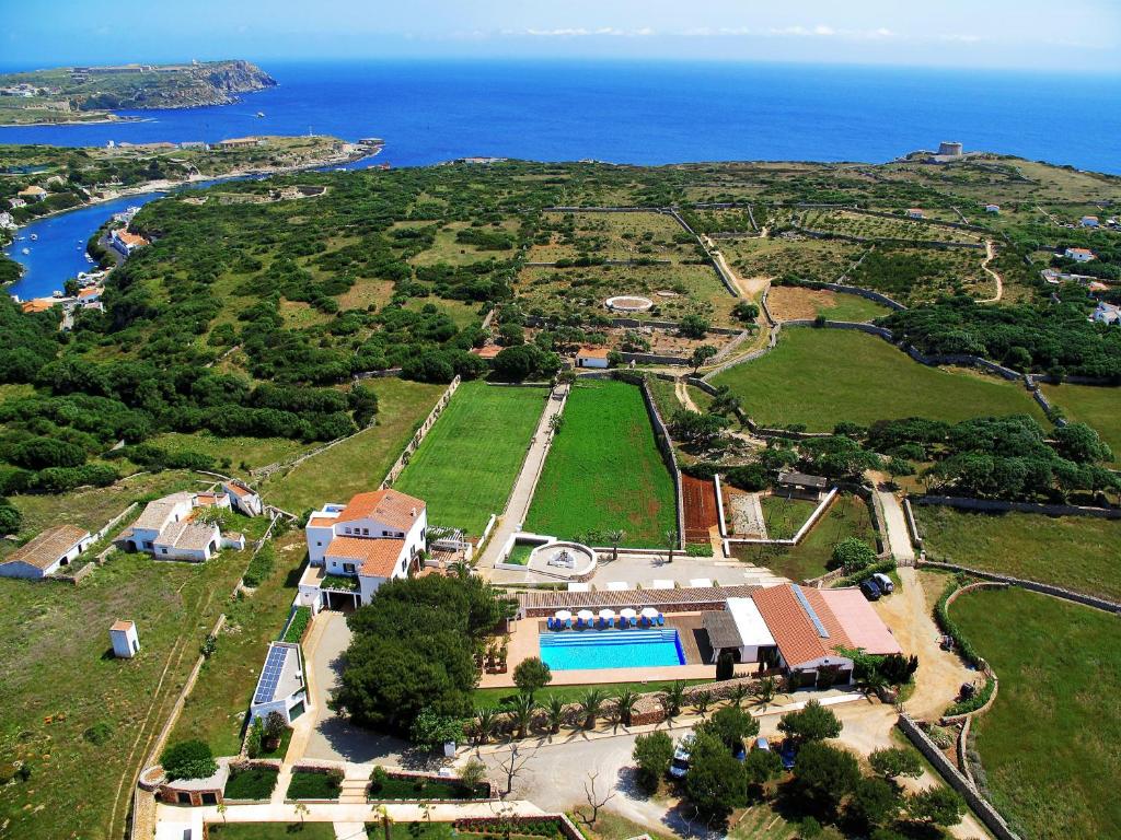 埃斯卡斯特利Hotel Rural Sant Joan de Binissaida的享有岛屿的空中景色,设有房屋和海洋