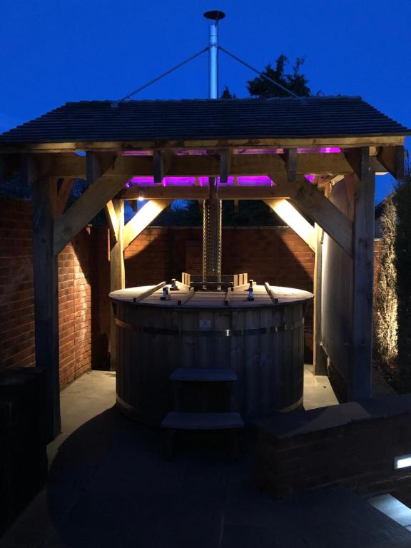 巴德利索尔特顿Herons Reach的木制凉亭,配有带紫色灯的热水浴池