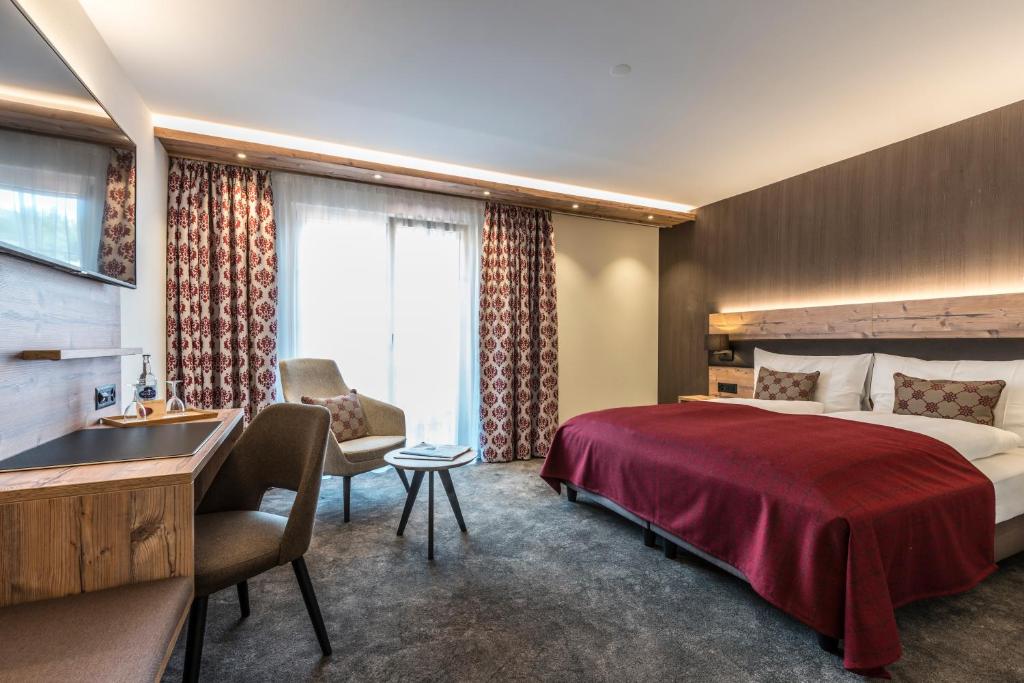 Gibswil基波斯威尔图博酒店的配有一张床和一张书桌的酒店客房