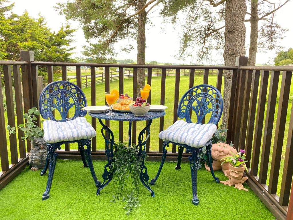 彭里斯Lake District romantic get away in 1 acre gardens off M6的天井上的桌子和两把椅子,上面放着一碗食物