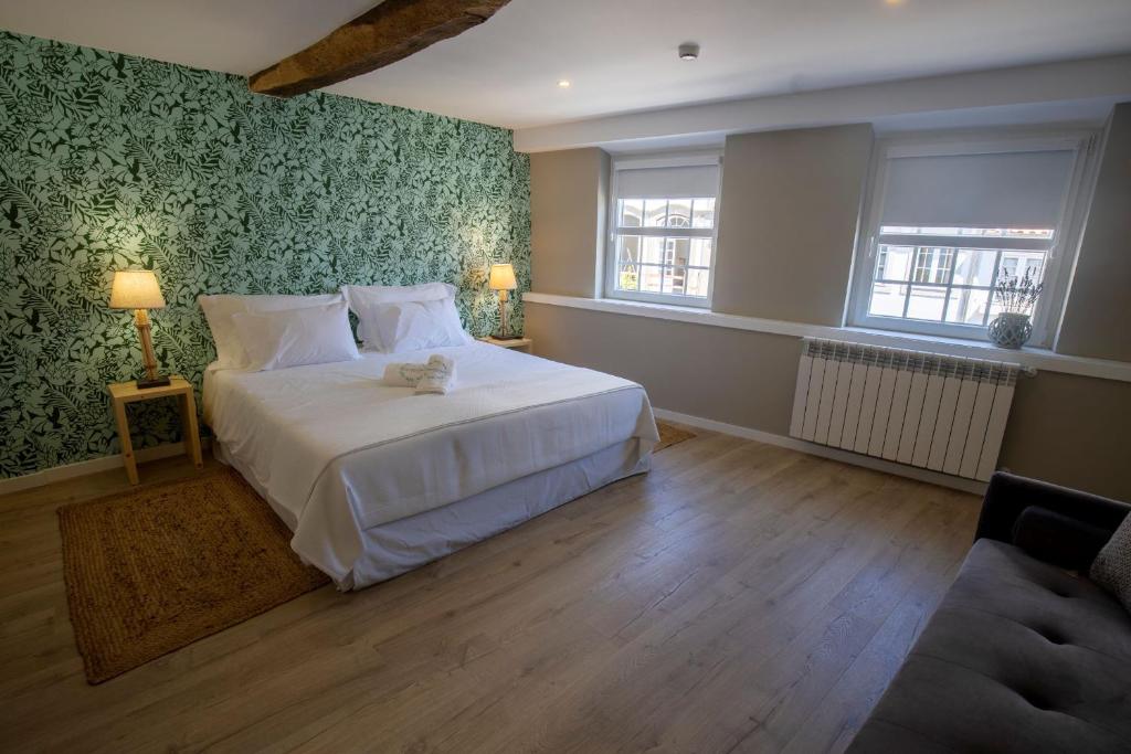 布拉干萨Secret Garden in Bragança的卧室配有一张白色大床和绿色壁纸