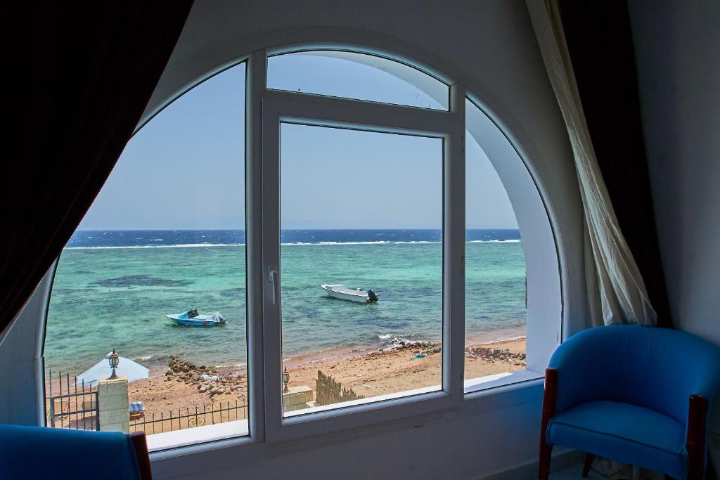达哈布Solaris的享有海滩美景的窗户,在水中设有船只