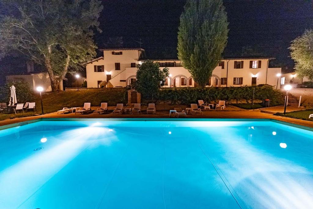 古比奥阿巴迪亚法内托公寓式酒店的夜间在房子前面的游泳池