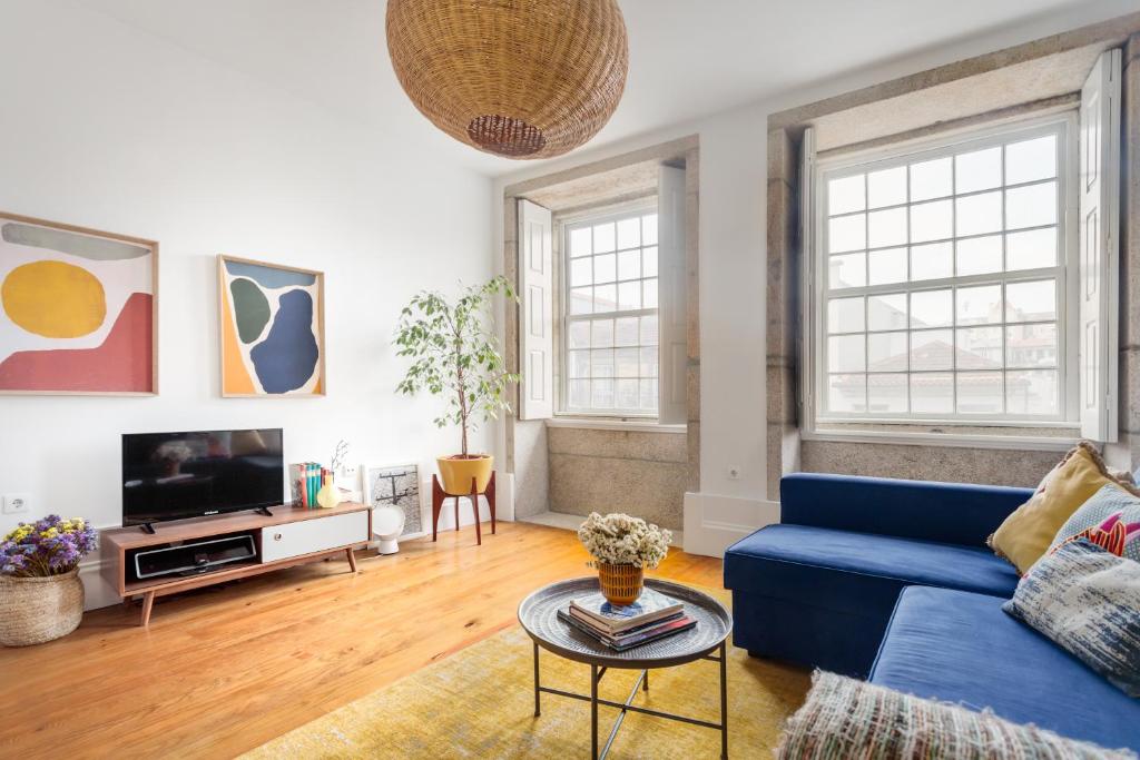 波尔图Own Places Clérigos Apartments的客厅配有蓝色的沙发和电视