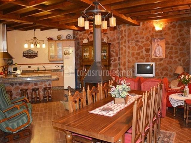 卡斯特里尔Alojamiento Rural El Chorrillo的一间带木桌的客厅和一间厨房