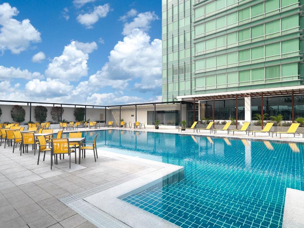 吉隆坡St Giles Boulevard的一座带桌椅的游泳池以及一座建筑