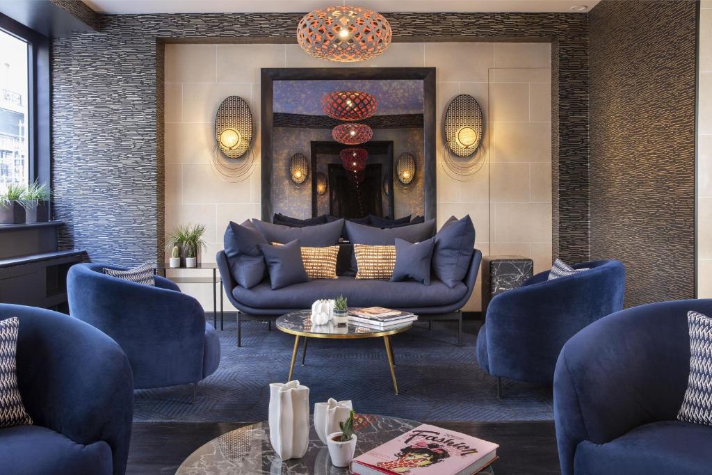 巴黎香榭丽舍雷格西亚酒店的客厅配有蓝色的沙发和桌子