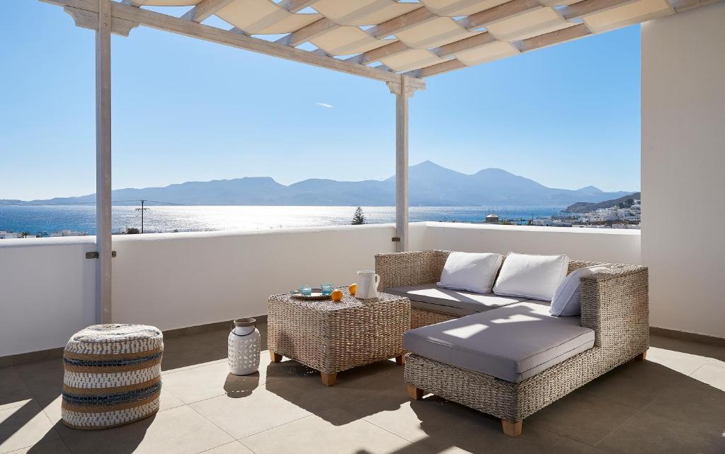 阿达玛斯Santa Maria Luxury Suites & Spa的天井配有沙发、椅子和桌子