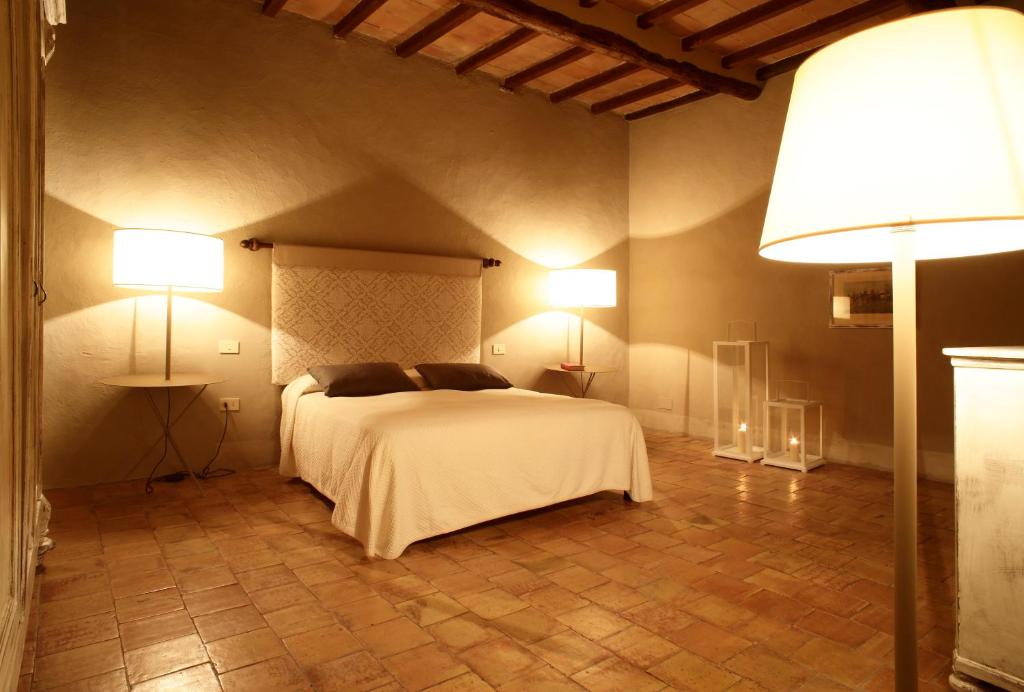 蒙塔尔奇诺Colle al Matrichese - Historic Winery的卧室配有白色的床和两盏灯。