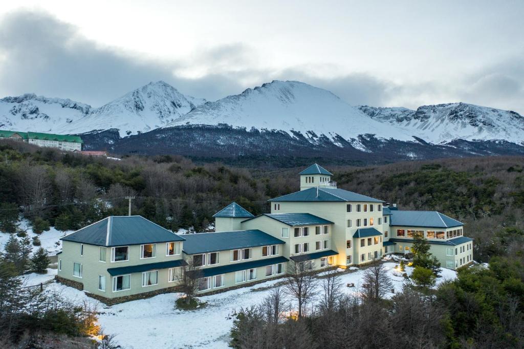 乌斯怀亚罗斯艾斯波斯乌斯怀亚酒店的一座大建筑,背景是积雪覆盖的群山