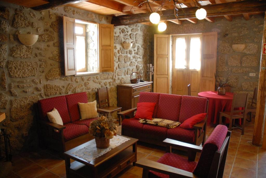 萨布盖鲁Casa da Moreia的客厅配有两张红色的沙发和一张桌子