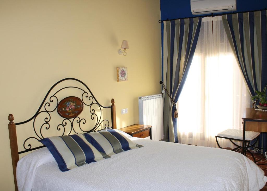 Valdealgorfa萨尔瓦多科拉尔瓦莱罗乡村别墅的卧室配有白色的床和窗户。