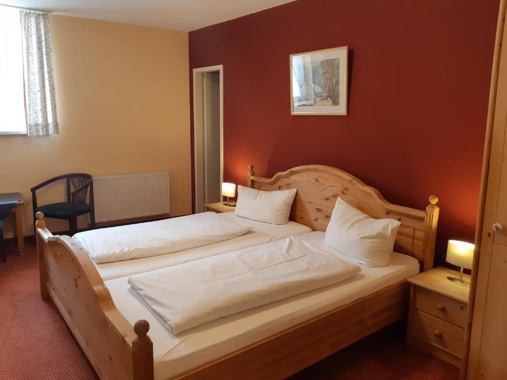 加尔米施-帕滕基兴威尔登菲尔赛霍夫酒店的一间卧室配有两张带白色床单的床