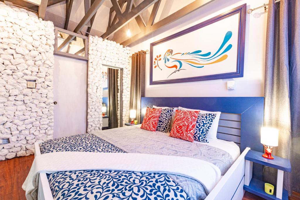 拿骚Parrot Cottage at Viking Hill - Love Beach的卧室配有一张床,墙上挂有绘画作品