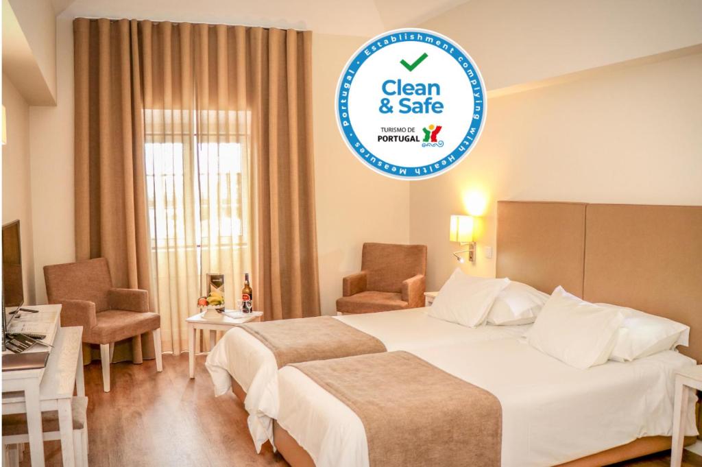 圣克鲁斯Hotel Solar Bom Jesus的酒店客房设有两张床和一个标牌,标牌上写着干净、安全的