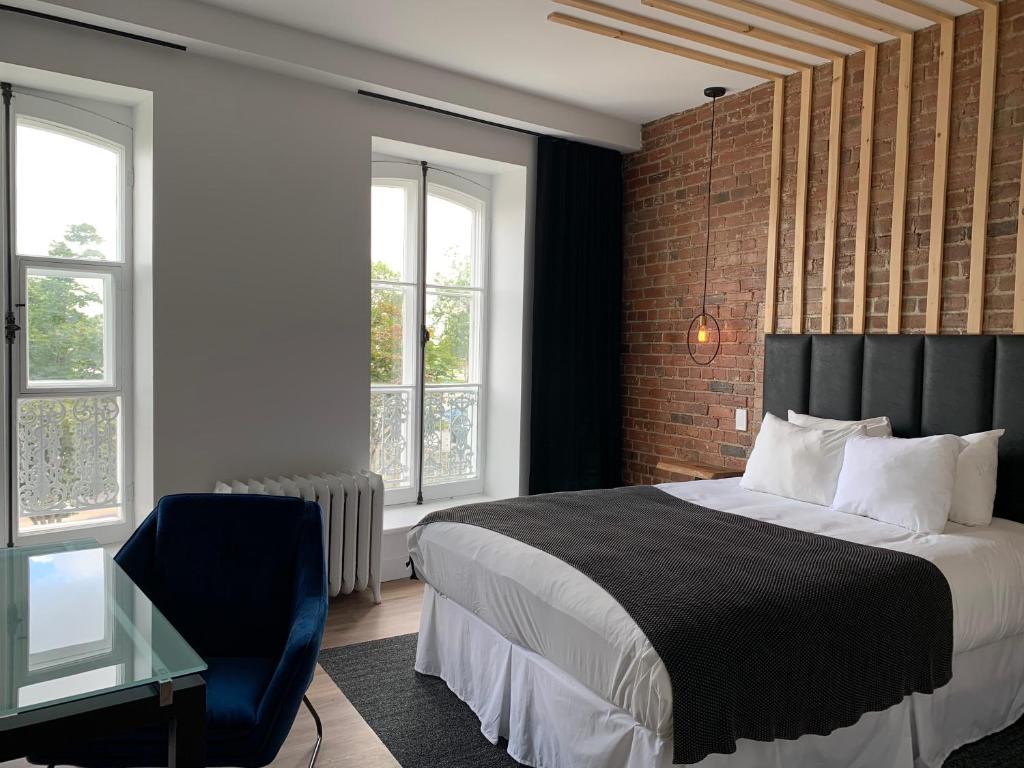 魁北克市圣保罗勒酒店的一间卧室配有一张床、一把椅子和窗户。
