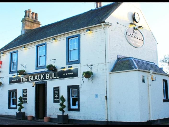 波尔蒙特The Blackbull Inn Polmont的上面有黑公牛标志的白色建筑
