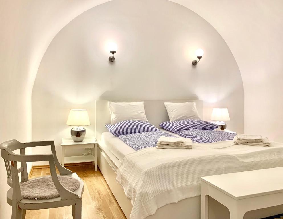 梅尔克Altstadt Apartments Melk mit Sauna的白色卧室配有床和椅子