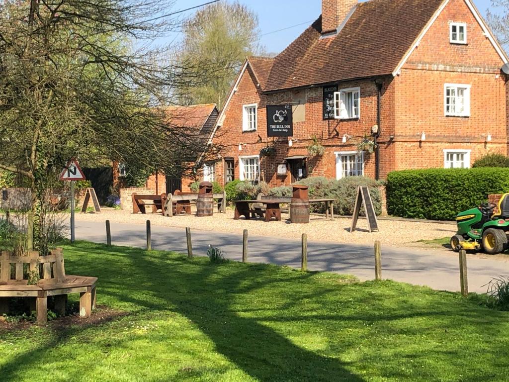 Stanford DingleyThe Bull Inn Pub的建筑前草上长凳的建筑物