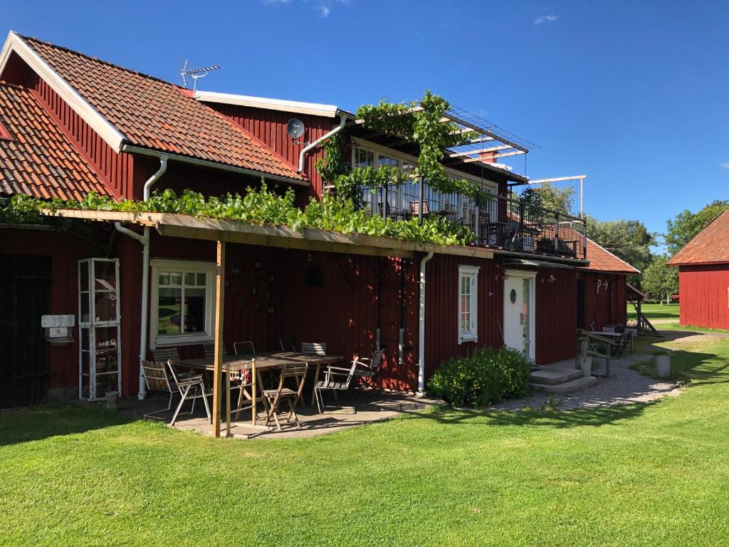 Källby琴纳库勒冒险农场旅馆的院子里的红色房子,配有桌椅