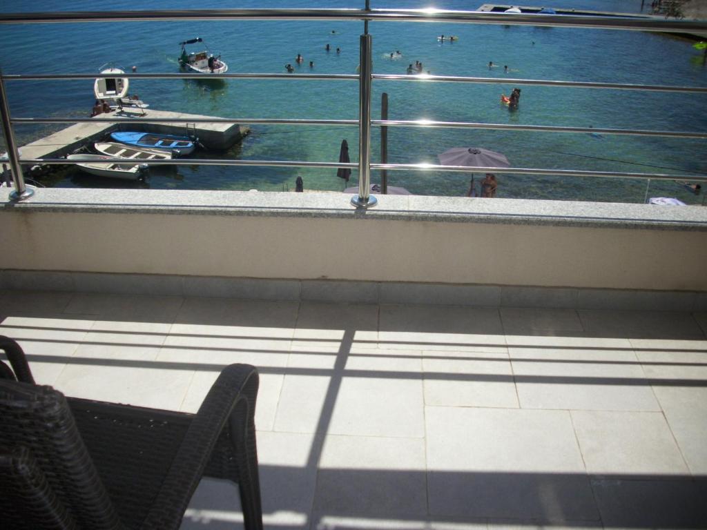 赞吉纳Apartments Kala的阳台享有泳池美景,配有桌椅。