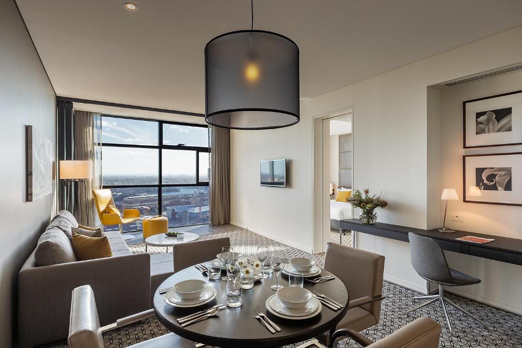 悉尼悉尼辉盛阁国际公寓的用餐室以及带桌椅的起居室。