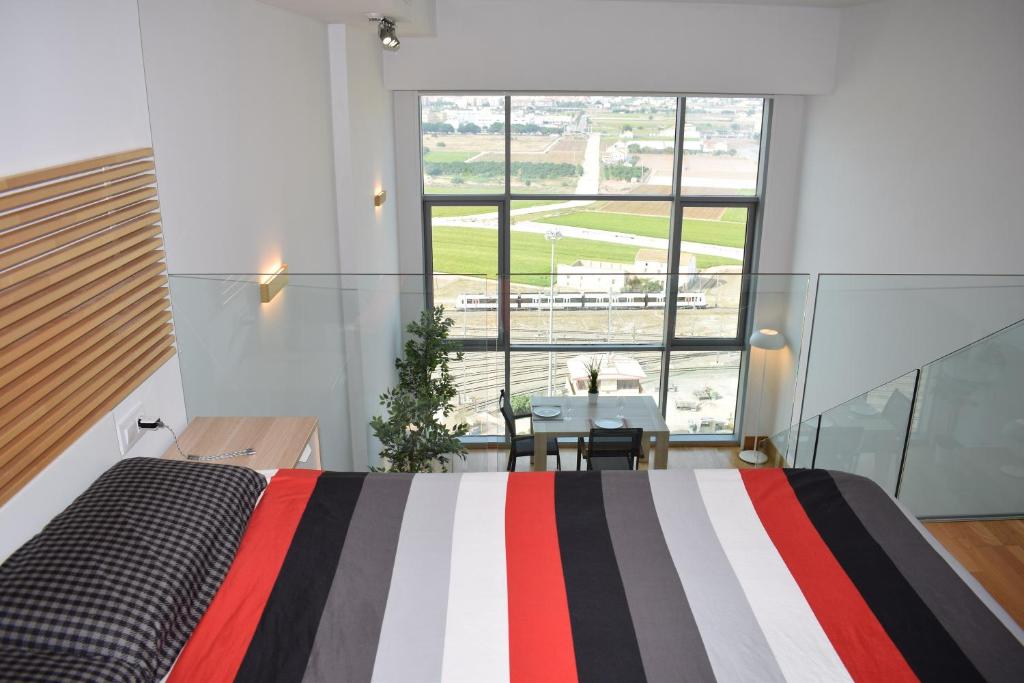 瓦伦西亚Duplex LOFT Apartamento con Parking GRATIS的一间卧室配有一张床、一张桌子和一个窗户。