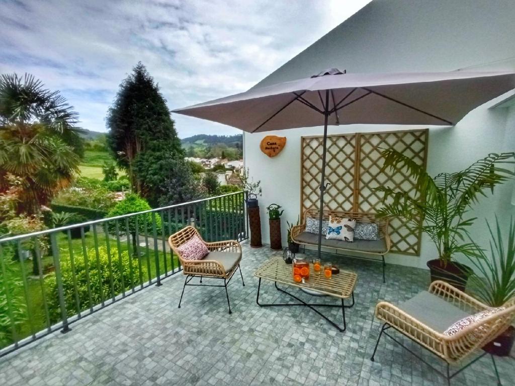 富尔纳斯Casa Pacheco的庭院配有椅子、遮阳伞和桌子。